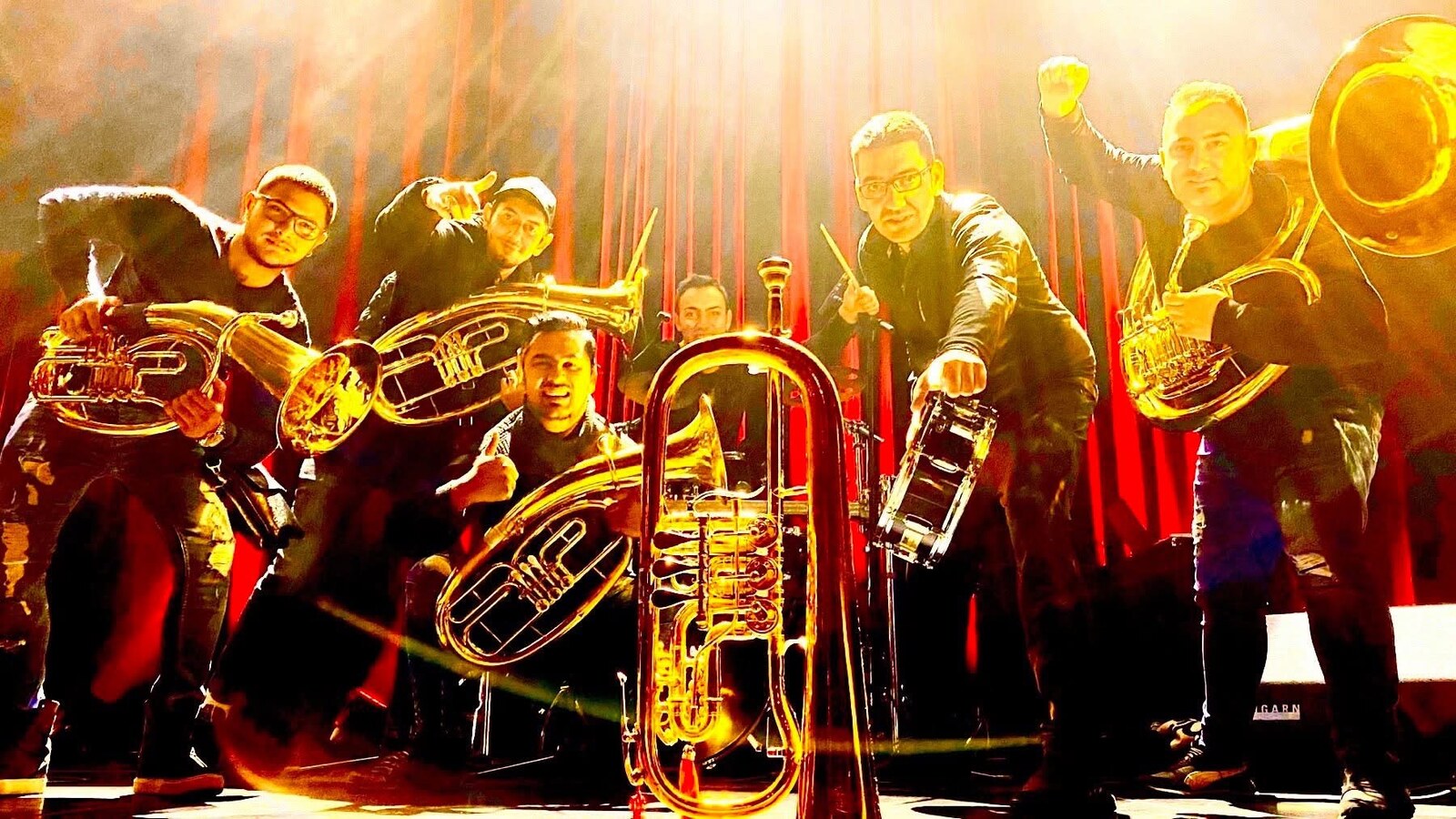 Orkestar u kontra-svetlu na bini, tube i doboš u prvom planu