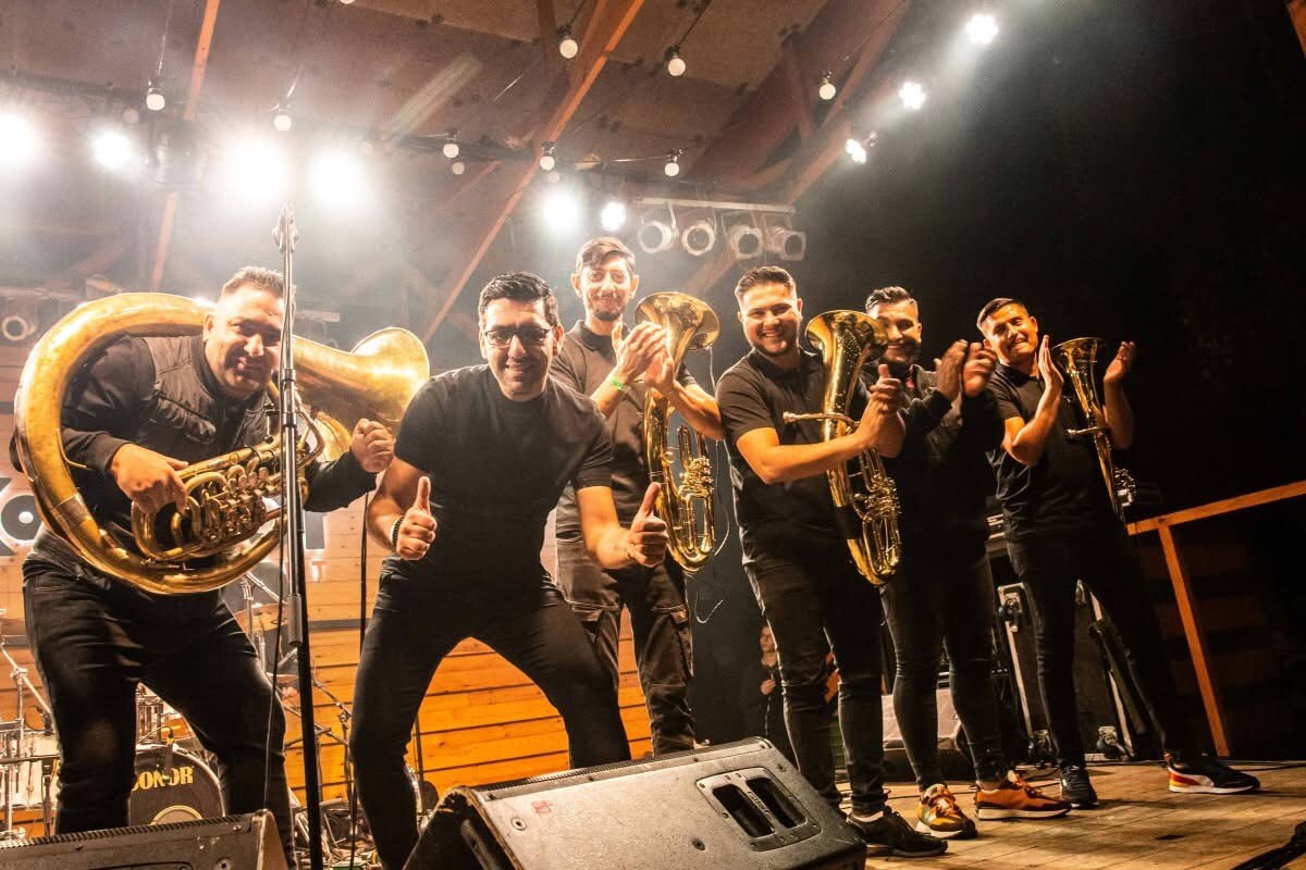 Večernji nastup pod drvenom nadstrešnicom, muzičari sa tubama i trubama