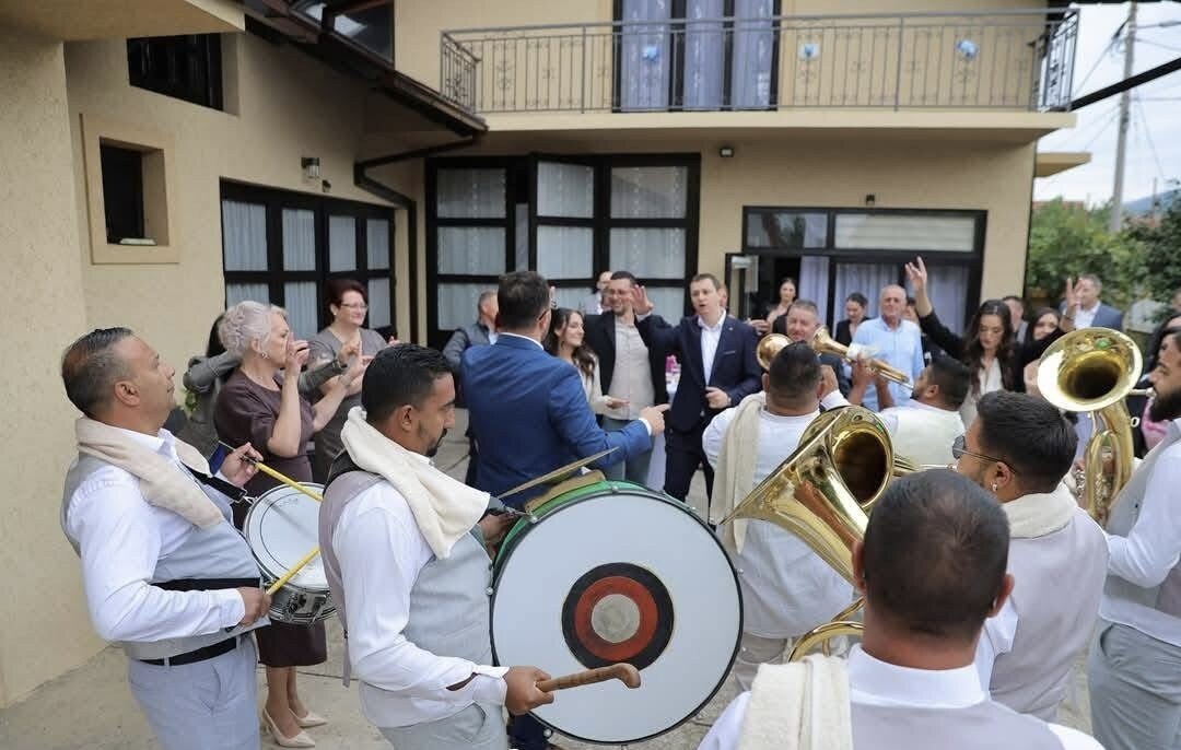 Sviranje u dvorištu na svadbi — tapan, tube i gosti oko orkestra